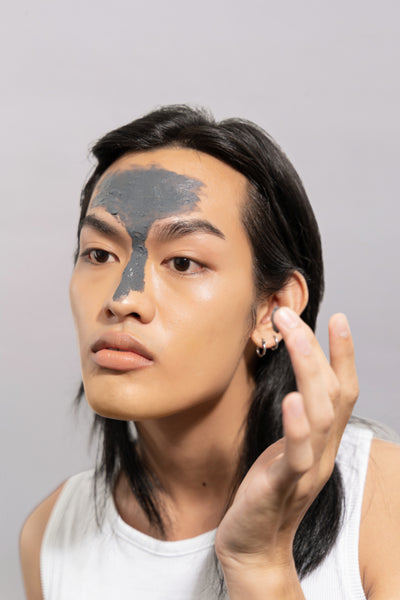 A skincare model using the clarifying face mask by Brooklyn-based skincare brand Alder New York. This mud mask has bentonite clay and gentle exfoliants to remove oil and fight acne breakouts.